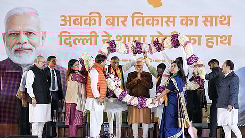 Prime Minister Narendra Modi garlanded by BJP MPs Manoj Tiwari, Bansuri Swaraj, and others during the celebrations of the party's win in the Delhi Assembly Election at the party headquarters in New Delhi on Saturday.