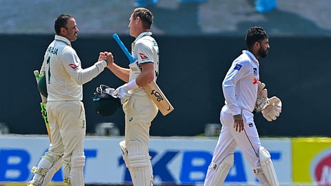 Australia's Usman Khawaja (L) and Marnus Labuschagne celebrate after their team's win at the end of the second Test cricket match between Sri Lanka and Australia at the Galle International Cricket Stadium in Galle on February 9, 2025.