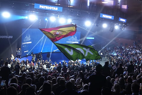 A Spanish flag and a Spanish far-right VOX party flag are waved during the far-right Patriots for Europe summit in Madrid, Spain, Saturday, Feb. 8, 2025.