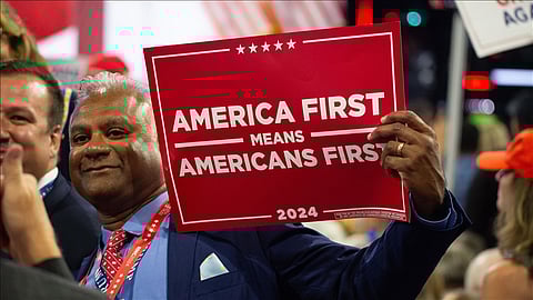 A Trump supporter holding an 'America First' poster