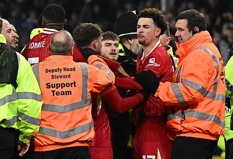 Liverpool's English midfielder Curtis Jones is held back by stewards as he remonstrates with Everton players after the English Premier League match between Everton and Liverpool at Goodison Park (Photo | AFP)