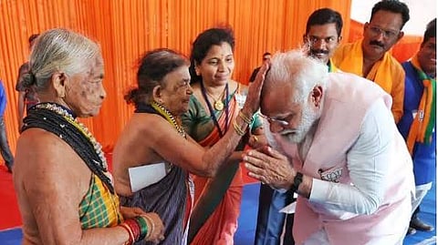 Prime Minister Narendra Modi bows to Tulasi Gowda and Sukrajji during his election campaign in Uttara Kannada district.