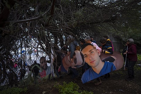 Activists holding photos depicting the faces of Israeli hostages held in the Gaza Strip, during a protest demanding their release from Hamas captivity, in Tel Aviv, Israel, Thursday, Feb. 13, 2025.