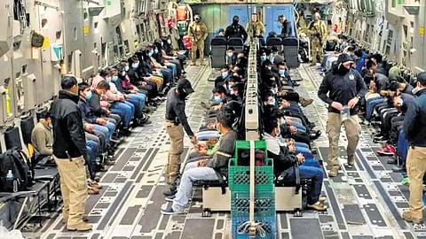 Cuffed and shackled illegal Indian migrants being deported on a US military aircraft.