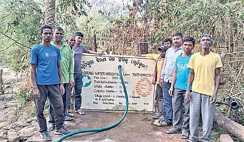 The villagers with the pipeline which irrigates their farmland