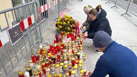 People light candles at the site of stabbing a day after an attack that left a 14-year-old dead and five others injured, in Villach, Austria, Sunday, Feb. 16, 2025.