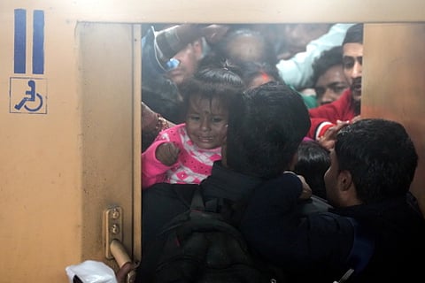 Heavy rush of passengers to catch a train for Mahakumbh, at the New Delhi railway station, Saturday, Feb. 15, 2025.