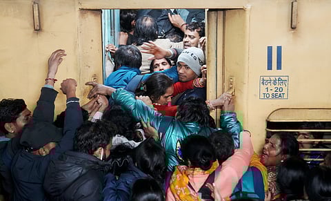 People board an overcrowded train for Prayagraj's Mahakumbh, at the New Delhi railway station