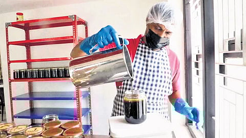 A worker filling the bottle with cane syrup