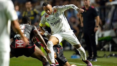 Brazil's Neymar is tackled as he chases a ball during his debut for Santos FC in a Sao Paulo league soccer match against Botafogo-SP, in Santos, Brazil, Wednesday, Feb. 5, 2025.