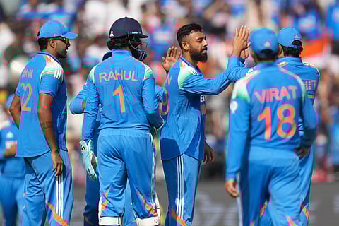 Varun Chakravarthy celebrates with teammates after the dismissal of Phil Salt during the second ODI against England in Cuttack (Photo | AP)