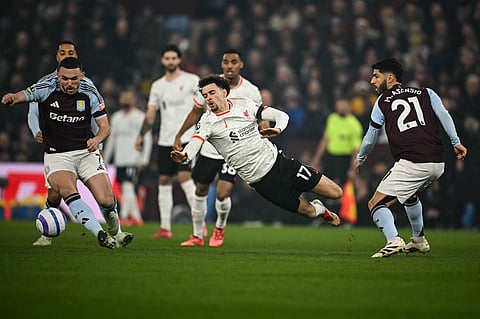 Liverpool's Curtis Jones (C) reacts as he is fouled by Aston Villa's Spanish midfielder #21 Marco Asensio (R) during the EPL football match between Aston Villa and Liverpool on February 19, 2025.