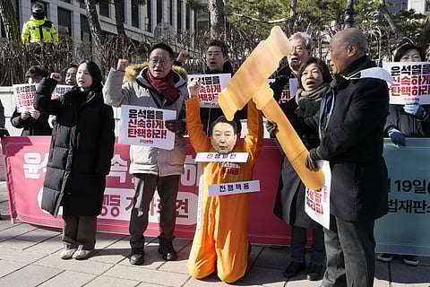 A protester wearing a mask of impeached South Korean President Yoon Suk Yeol attends with his fellow protesters during a rally calling for Yoon to step down in front of the Constitutional Court in Seoul, South Korea, Wednesday, Feb 19, 2025.