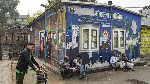 People take rest outside a Mohalla Clinic, in New Delhi.
