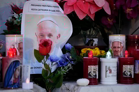 Candles are seen near pictures of Pope Francis outside the Agostino Gemelli Polyclinic in Rome, Sunday, Feb. 23, 2025, where the pontiff has been hospitalised since Feb. 14.