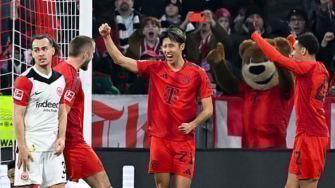 Munich's Hiroki Ito, center, celebrates scoring with Eric Dier, left, and Jamal Musiala during the Bundesliga soccer match between Bayern Munich and Eintracht Frankfurt.