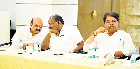 Union minister HD Kumaraswamy has a word with former chief minister and BJP MP Basavaraj Bommai, as Leader of Opposition in the Assembly R Ashoka looks on, at a BJP-JDS coordination committee meeting in Bengaluru on Tuesday