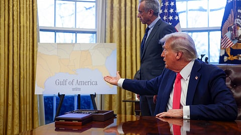 President Donald Trump gestures to a poster reading "Gulf of America" in the Oval Office at the White House in Washington, Tuesday, Feb. 25, 2025.