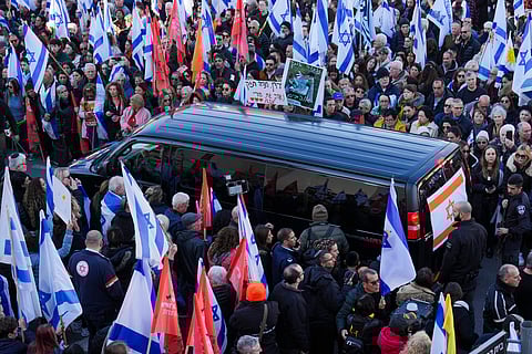 Mourners gather around the convoy carrying the coffins of slain hostages Shiri Bibas and her two children, Ariel and Kfir, during their funeral procession in Rishon Lezion, Israel, Wednesday, Feb. 26, 2025.
