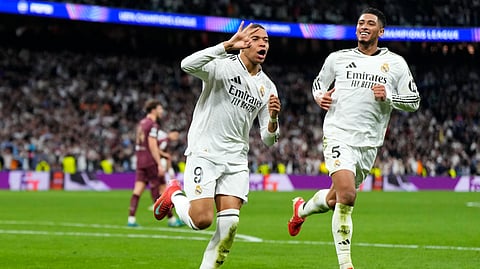 Real Madrid's Kylian Mbappe celebrates with Real Madrid's Jude Bellingham, right, after scoring his sides third goal during the Champions League playoff second leg soccer match between Real Madrid and Manchester City at the Santiago Bernabeu Stadium in Madrid, Spain, Wednesday, Feb. 19, 2025.