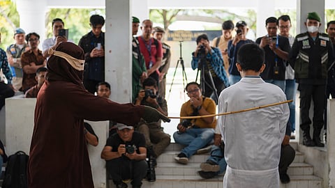 A Shariah law official uses a rattan cane to whip one of two men convicted of gay sex in Banda Aceh, Aceh province, Indonesia, Thursday, Feb. 27, 2025.