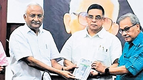 Former chief secretary S M Vijayanand handing over a copy of Namukkenthupatti Suhurthe?’ written by the late Vishnunarayanan Namboothiri to K N K Namboodiri at Thiruvananthapuram Press Club.