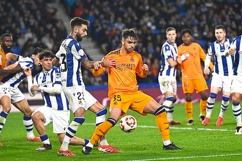 Real Sociedad's Brais Mendez, centre left, challenges for the ball with Real Madrid's Raul Asencio during the Spanish Copa del Rey soccer match between Real Sociedad and Real Madrid at the Reale Arena in San Sebastian, Spain, Wednesday, Feb. 26, 2025.