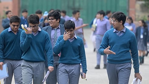 Students exit the examination center after appearing for the Class 12 CBSE exam in New Delhi.