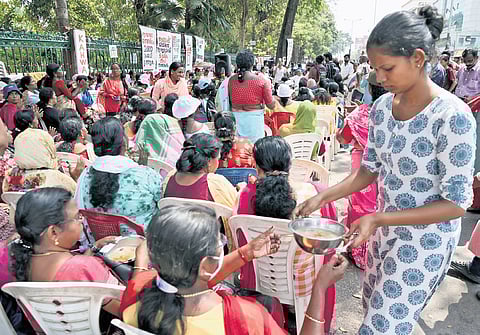 A volunteer serves midday meals to ASHA workers staging protest in front of the Secretariat in Thiruvananthapuram on Thursday