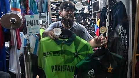 Mohammad Rizwan, a shopkeeper, displaying jerseys of Pakistan's national cricket team at his shop during the ongoing ICC Champions Trophy in Karachi.