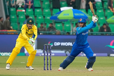 Afghanistan's Azmatullah Omarzai plays a shot as Australia's Josh Inglis watches during their ICC Champions Trophy match in Lahore (Photo | AP)