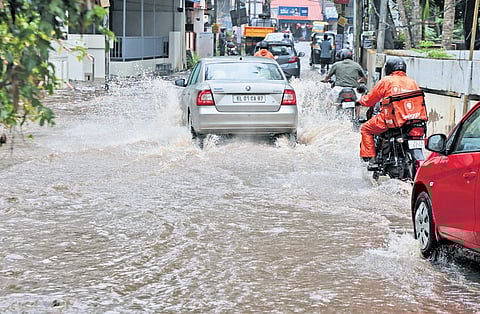 Vehicles moving on the flooded Pipinmoodu-Kowdiar road.