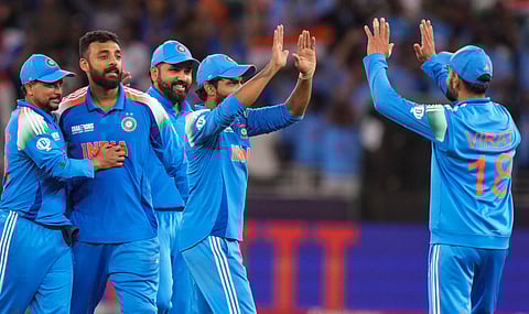 India's Varun Chakaravarthy with teammate Virat Kohli and others celebrates the wicket of New Zealand's Matt Henry during the ICC Champions Trophy cricket match between India and New Zealand, in Dubai, UAE, Sunday, March 2, 2025.