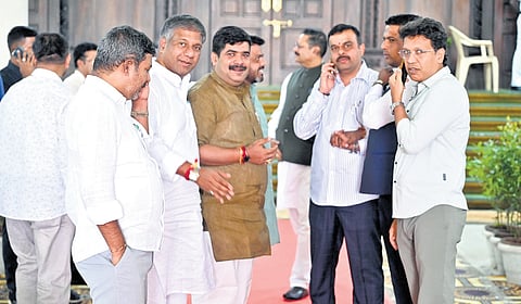 BJP legislators gather outside the House, during the ongoing session, at Vidhana Soudha in Bengaluru on Tuesday