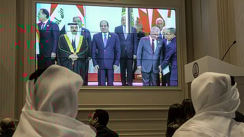 Journalists watch a screen displaying Egyptian President Abdel Fattah el-Sissi, center, with Arab Leaders, at the press center hall of the emergency Arab summit at Egypt's New Administrative Capital, just outside Cairo, Tuesday, March 4, 2025.