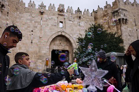 A boy makes soap bubbles at Damascus Gate in Jerusalem's Old City as Muslim worshippers leave after attending the first Ramadan Friday noon prayer, on March 7, 2025.