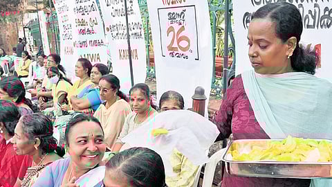 A volunteer distributing jackfruit to members of the Kerala ASHA Health Workers Association on Friday, the 26th day of their indefinite protest in front of the Secretariat.