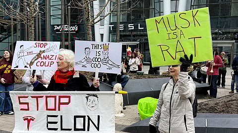 Protesters rally outside of a Tesla store in Boston, Saturday, March 1, 2025, against the company's CEO, Elon Musk, who is leading an effort to cut government jobs on behalf of President Donald Trump.