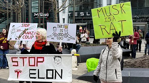 Protesters rally outside of a Tesla store in Boston, Saturday, March 1, 2025, against the company's CEO, Elon Musk, who is leading an effort to cut government jobs on behalf of President Donald Trump.