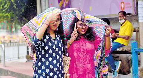Girls take cover under a shawl near Spencer’s Plaza on Tuesday