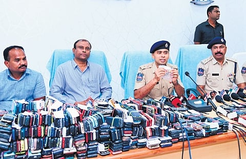 Police showcase the seized mobile phones at a press meet in Adilabad