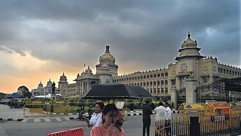 Pedestrians walk past the Vidhana Soudha in Bengaluru.