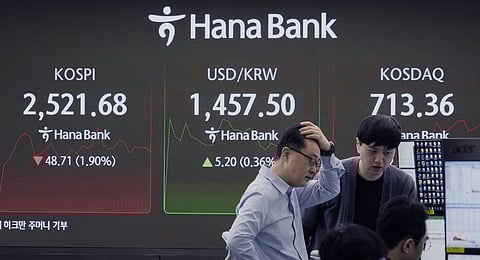 Currency traders watch monitors near a screen showing the Korea Composite Stock Price Index (KOSPI), left, and the foreign exchange rate between U.S. dollar and South Korean won, center, at the foreign exchange dealing room of the KEB Hana Bank headquarters in Seoul, South Korea, Tuesday, March 11, 2025.
