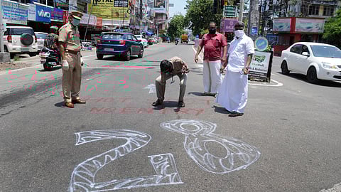 Police officers mark a Covid hotspot near Kaloor in Kochi