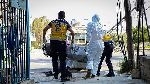 Members of the Syrian White Helmets collect the bodies of people found dead following a recent wave of violence between Syrian security forces and gunmen loyal to former President Bashar Assad, as well as subsequent sectarian attacks, in the coastal city of Baniyas, Syria, Sunday, March 9, 2025.