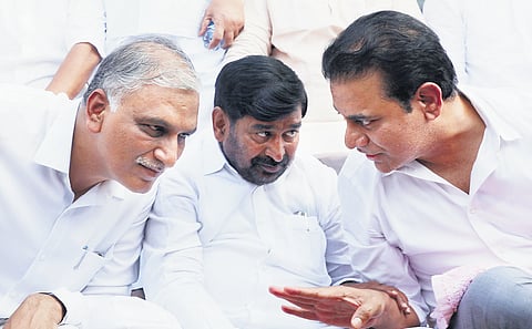 BRS working president KT Rama Rao speaks to T Harish Rao and Jagadish Reddy during a dharna the party staged near the Secretariat.