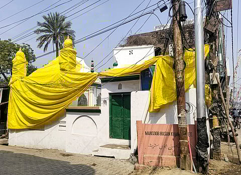 A mosque covered in tarpaulin as prevention against possible holi colour, ahead of traditional 'Laat Saheb' procession on Holi, in Shahjahanpur, Uttar Pradesh, Wednesday, March 12, 2025.