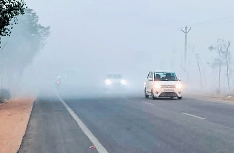 Thick smoke from the dumping yard near Nalgonda town envelops a road.