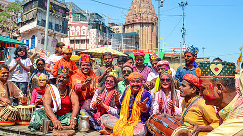 People sing a Holi song during celebrations of festival of colours, at Dashaswamedh Ghat in Varanasi, Wednesday, March 12, 2025.