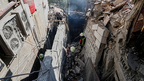 Firemen work at the site of an Israeli missile strike in Damascus, Syria.